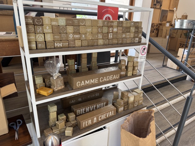 Intérieur de la boutique Savonnerie Fer à Cheval à Marseille avec comptoir marbre et rayonnages de produits naturels